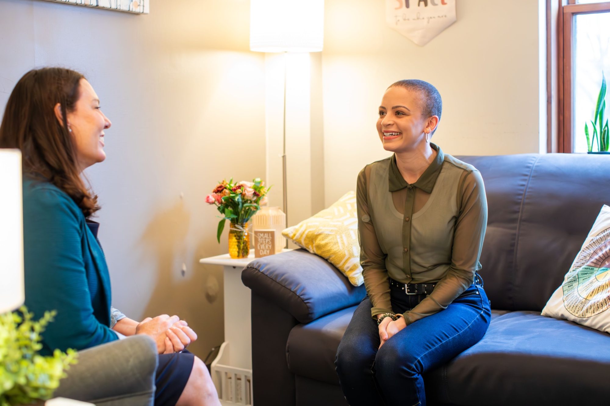 A client in an LGBTQ+ affirming therapy session with a Safe Space banner visible in the office