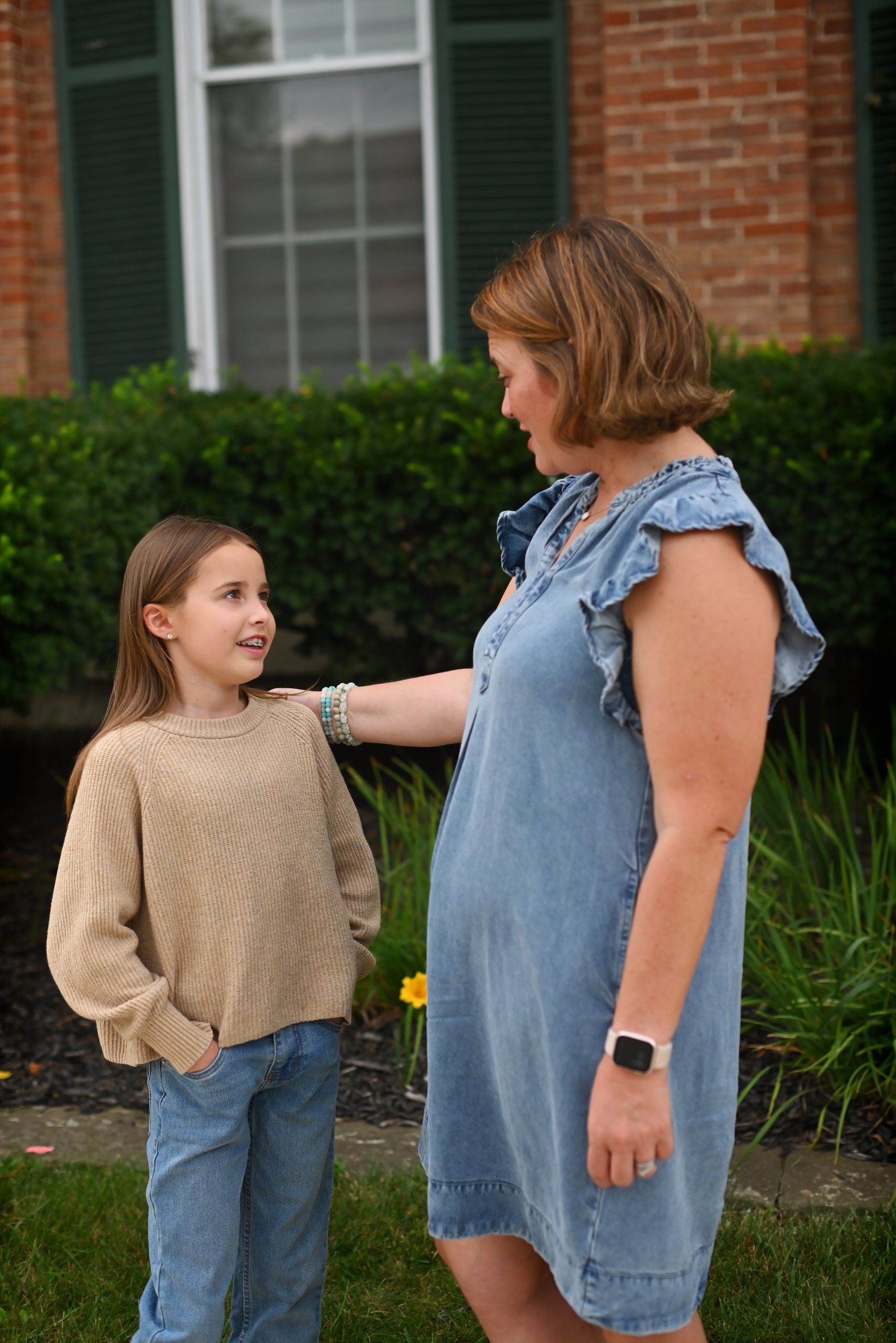 Smiling girl talking with her therapist outside the Troy, Ohio office, with a supportive hand on her shoulder