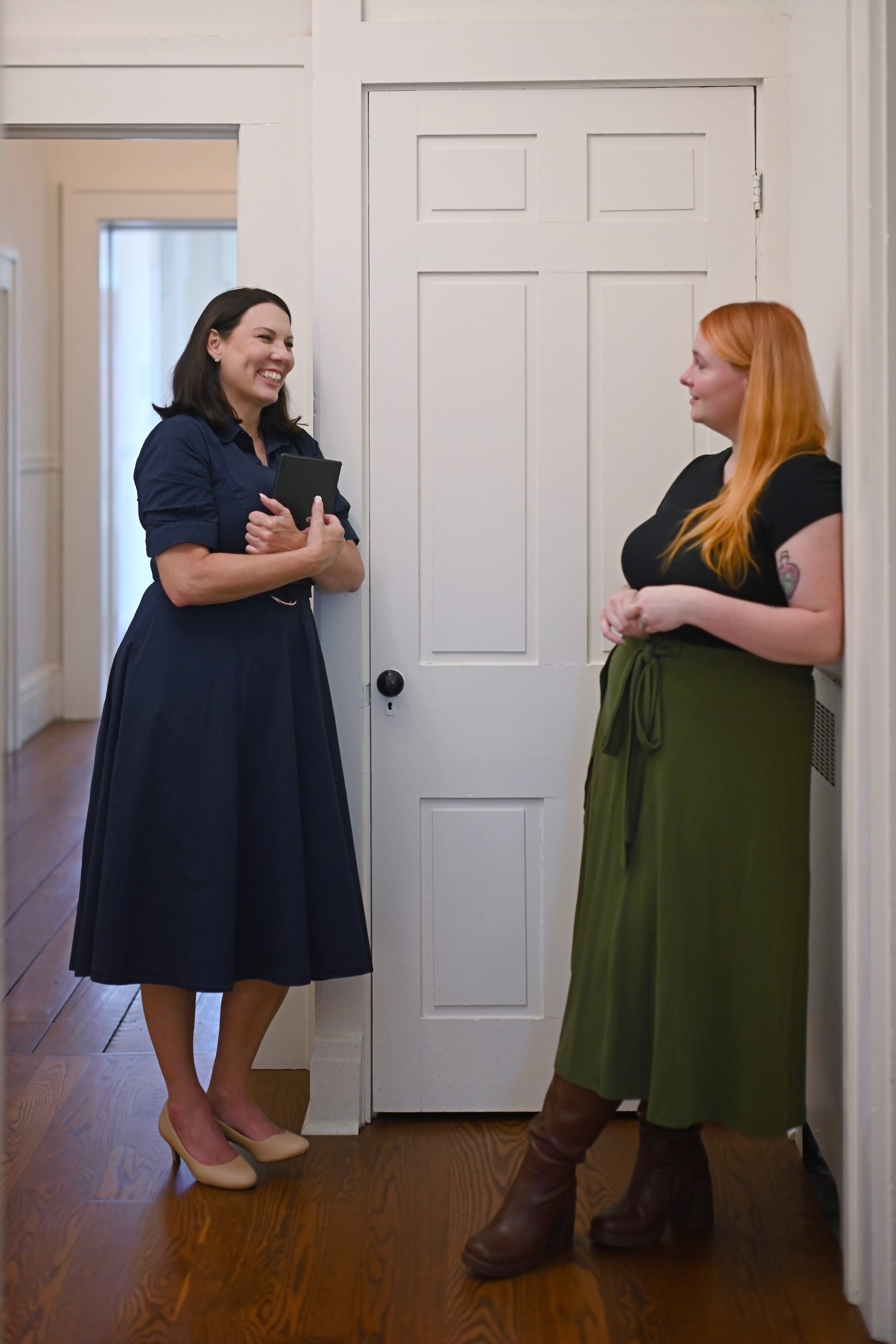 Two Holistic Consultation therapists sharing a laugh in the hallway of our Troy, Ohio office