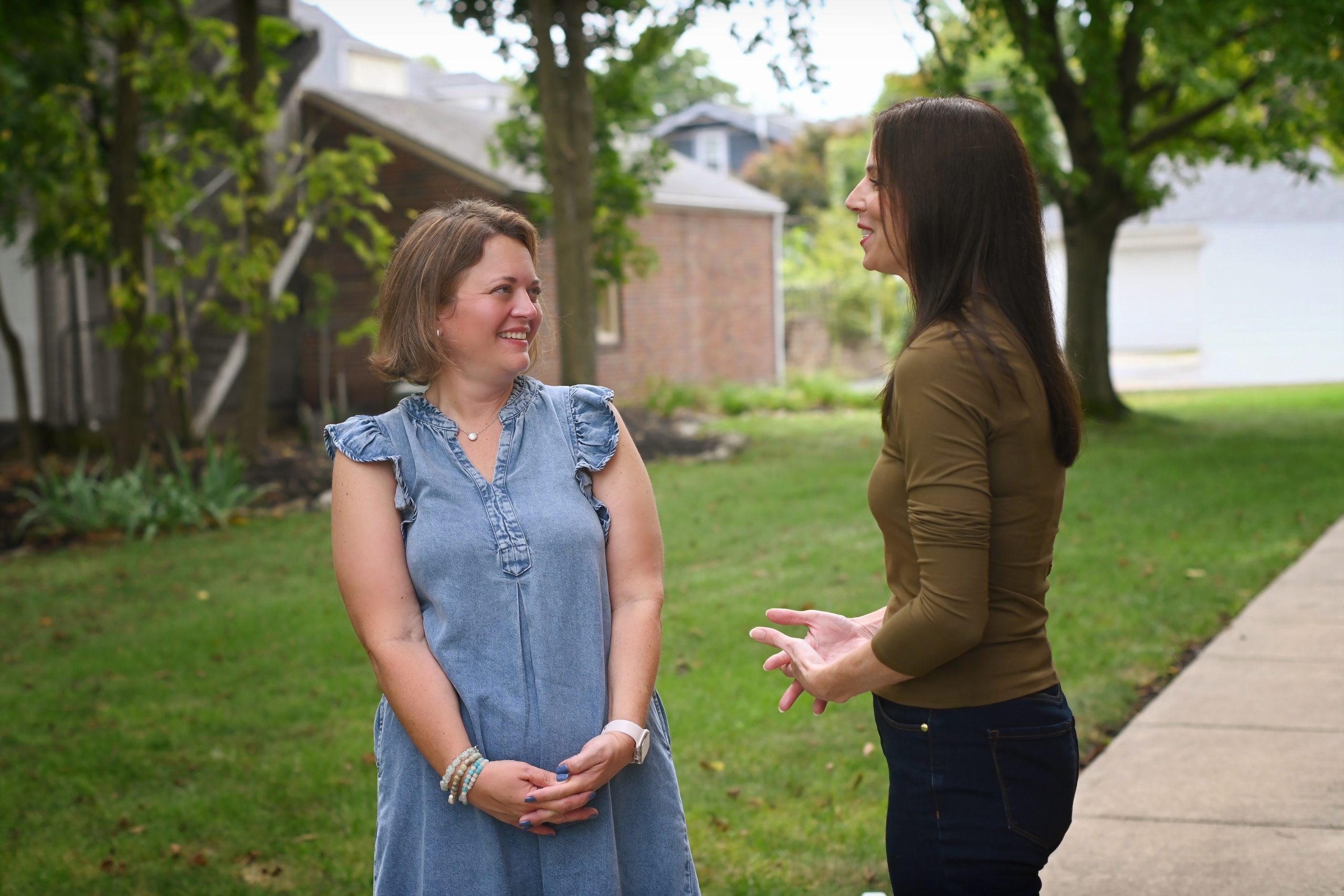 Therapist and client talking outdoors on a sunny lawn during a walk and talk therapy session in Troy, Ohio
