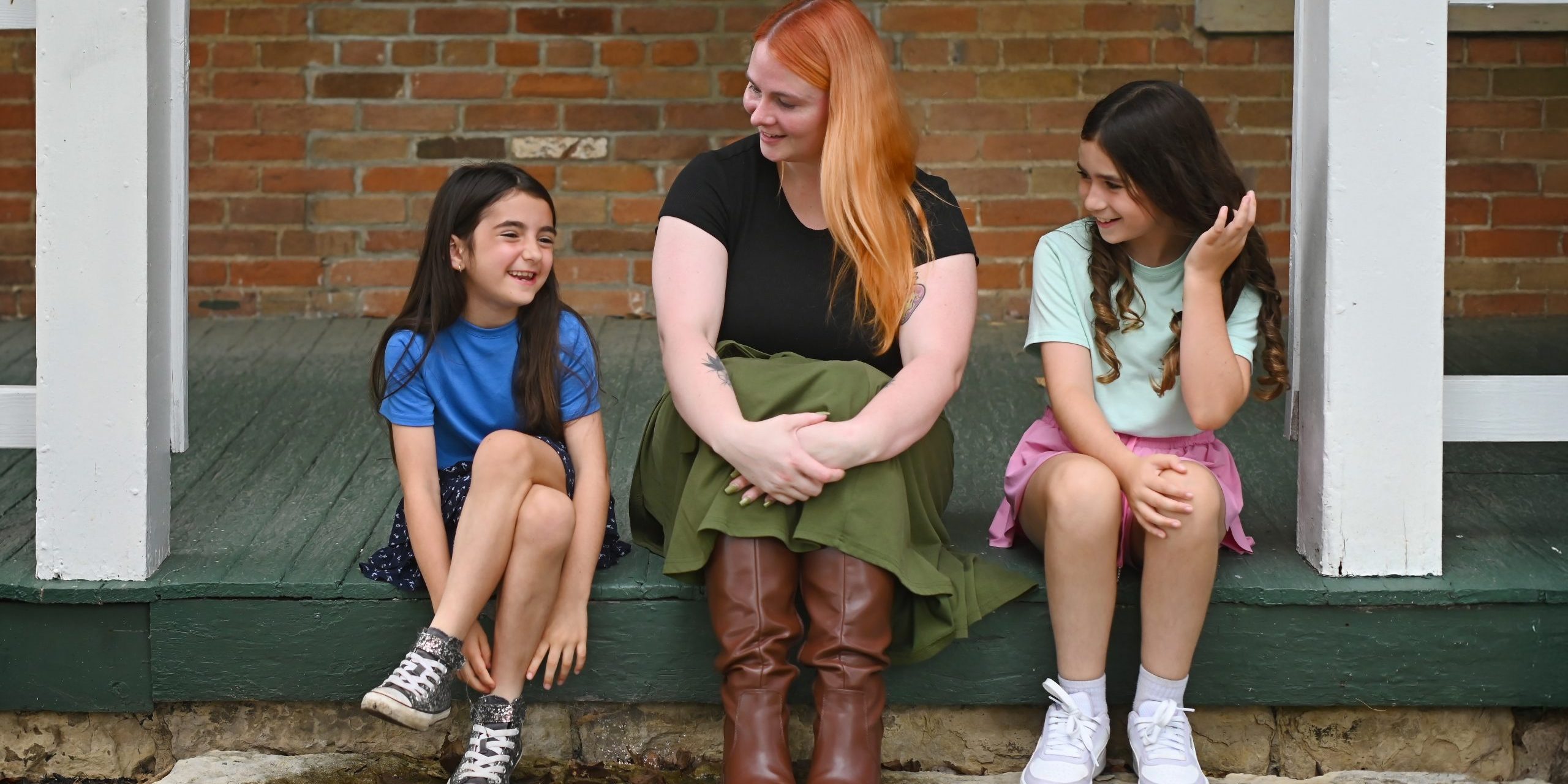 Therapist laughing with two young girls on the front porch of Holistic Consultation in Troy, Ohio