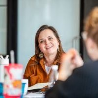 Team member smiling during a group discussion at a Holistic Consultation professional development event in Columbus, Ohio