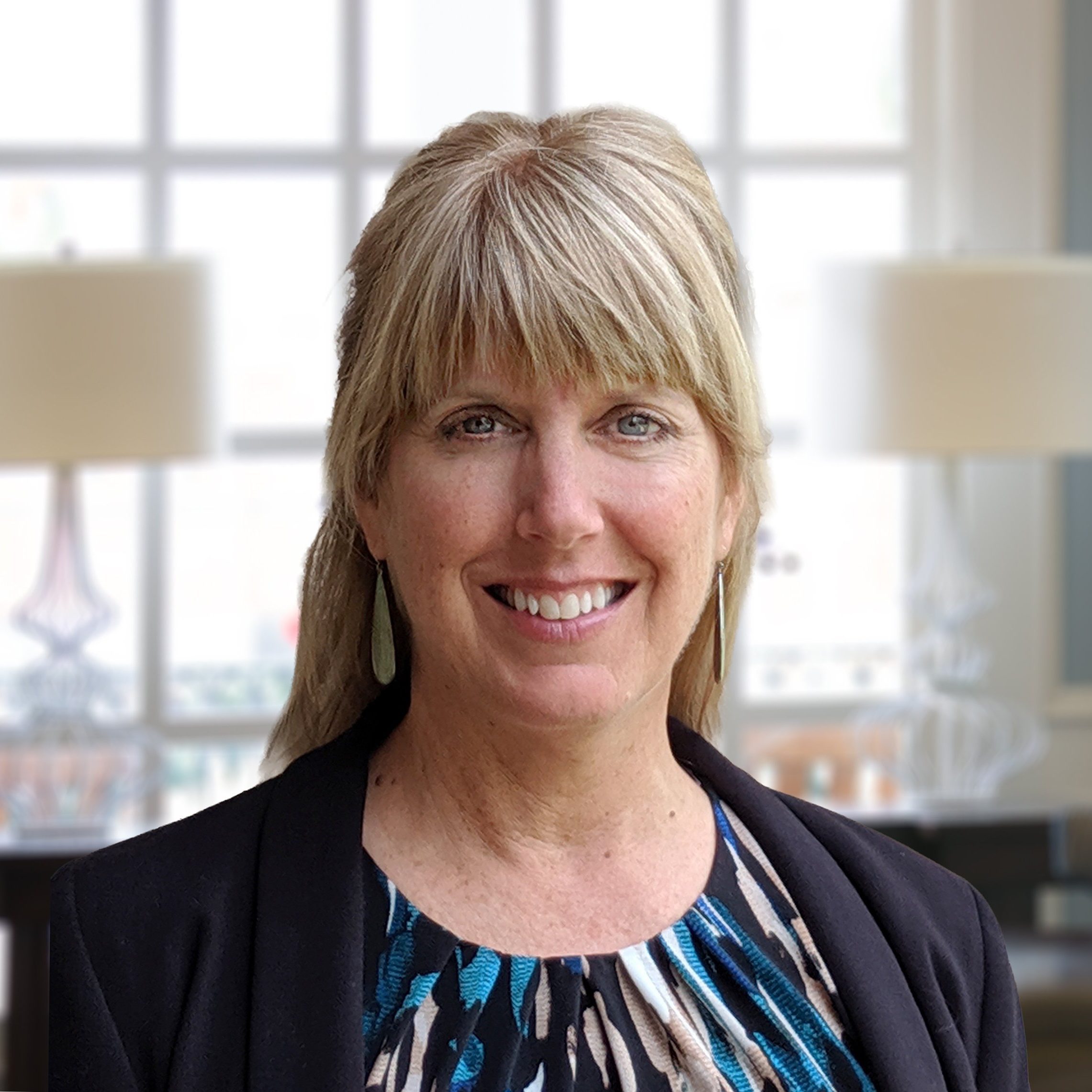 Julie Koloc, MA, LPCC, LMHC, smiling therapist providing online therapy across Ohio, specializing in trauma and somatic-focused care